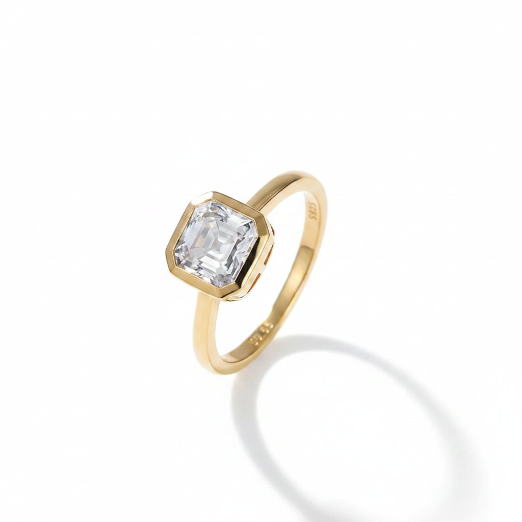 Gold ring with a asscher moissanite diamond on a white background