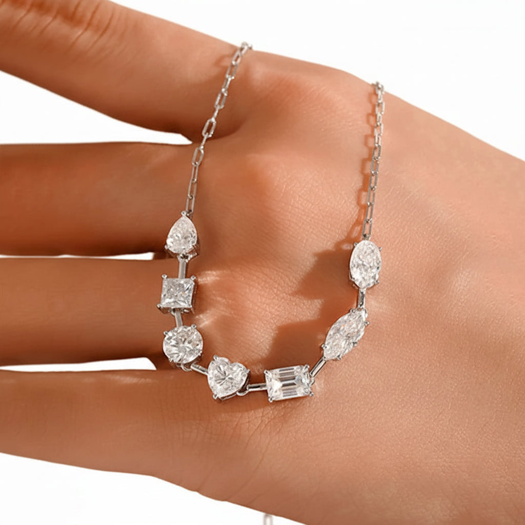 Silver necklace with moissanite gemstones on a hand against a neutral background
