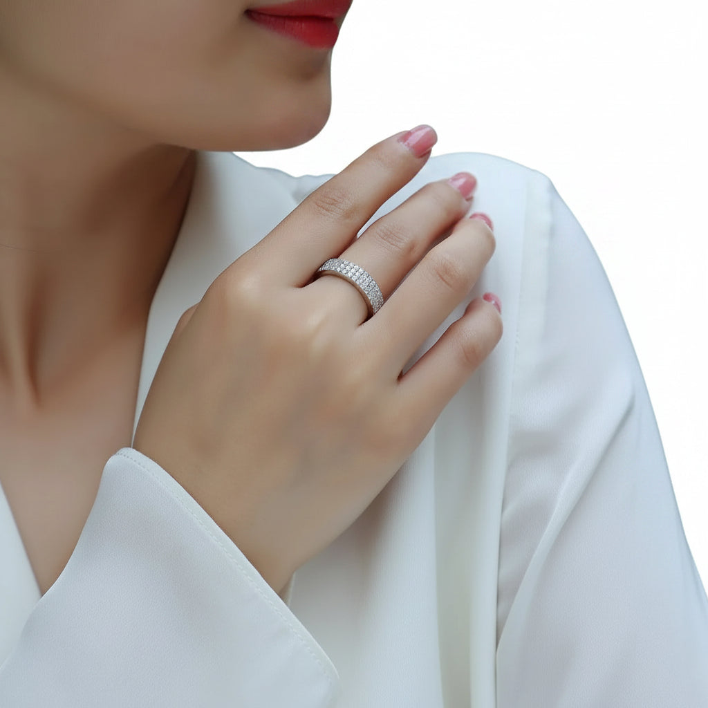 Close-up of a hand wearing a silver ring with a blurred background