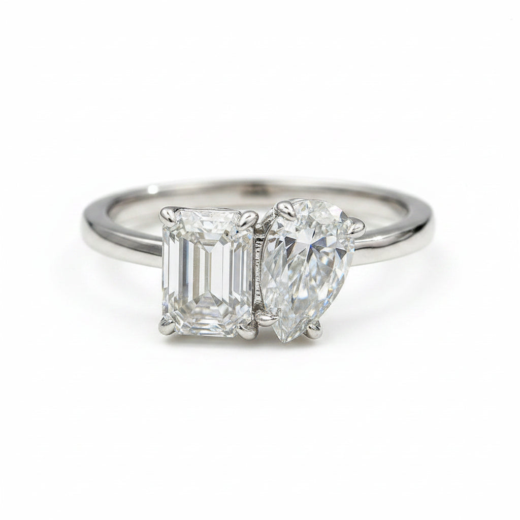 Diamond ring with two gemstones on a white background
