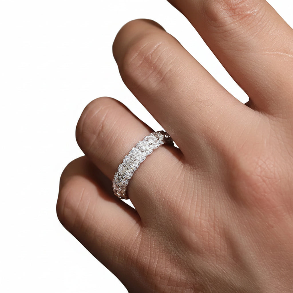 Close-up of a hand wearing a moissanite ring with a white background