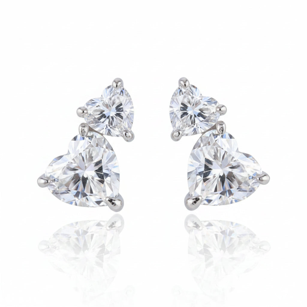 Pair of moissanite diamond earrings on a reflective white background