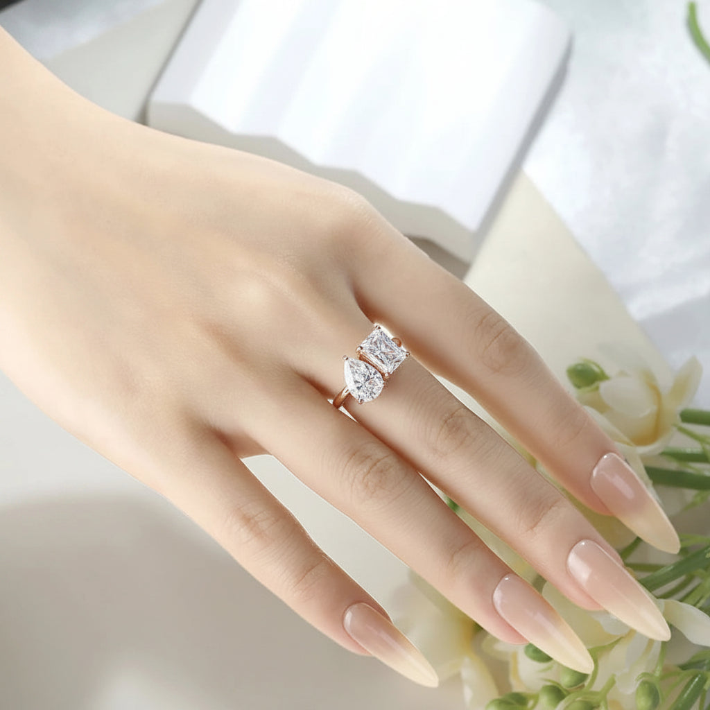Hand wearing a moissanite ring with a soft focus background