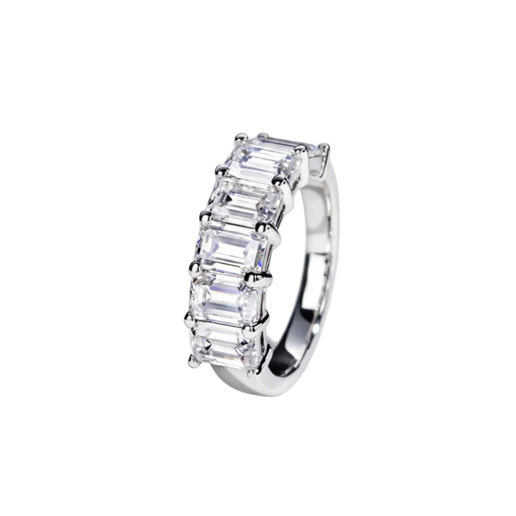 Silver ring with emerald-cut diamonds on a white background