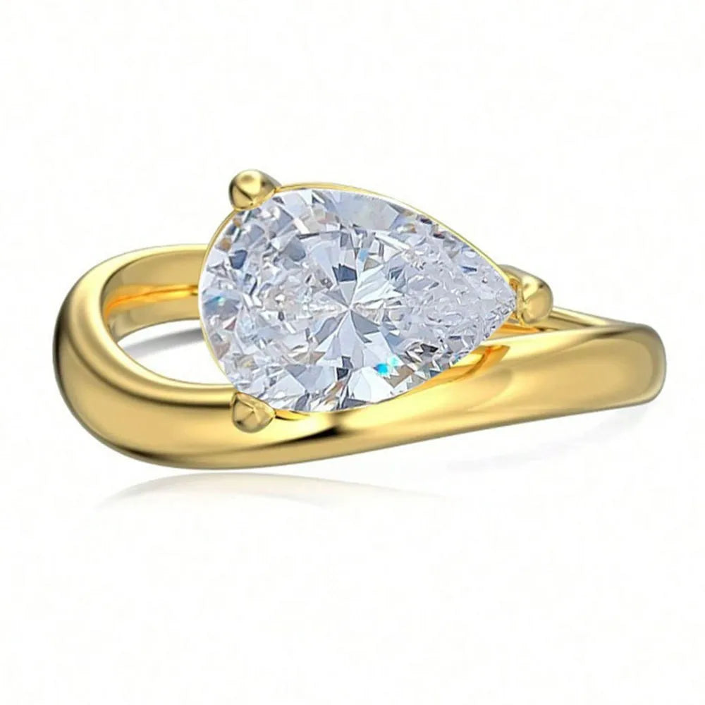 Gold ring with a pear-shaped diamond on a white background