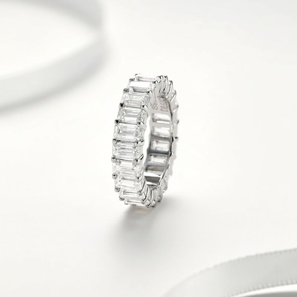 Moissanite ring with emerald-cut stones on a white background