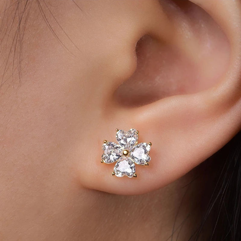 Gold earring with moissanite gemstones worn on an ear