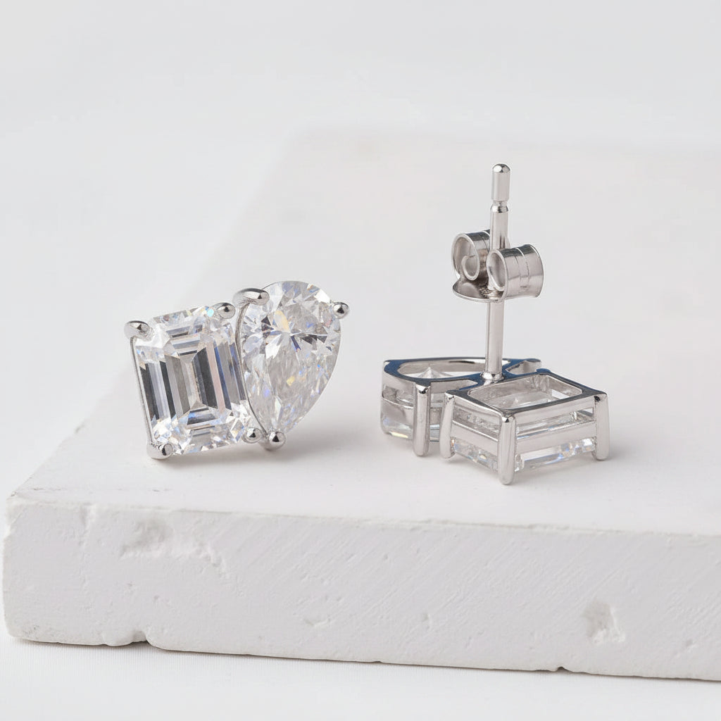 Diamond earrings on a white platform with a white background