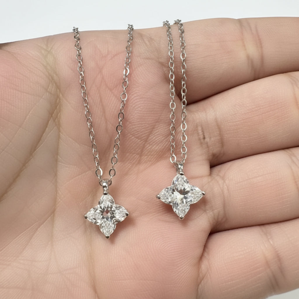 Silver necklace with star-shaped moissanite diamond pendants held on a palm