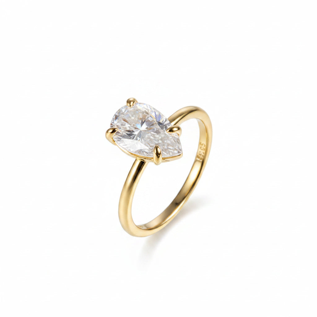 Yellow gold ring with a large pear moissanite diamond on a white background