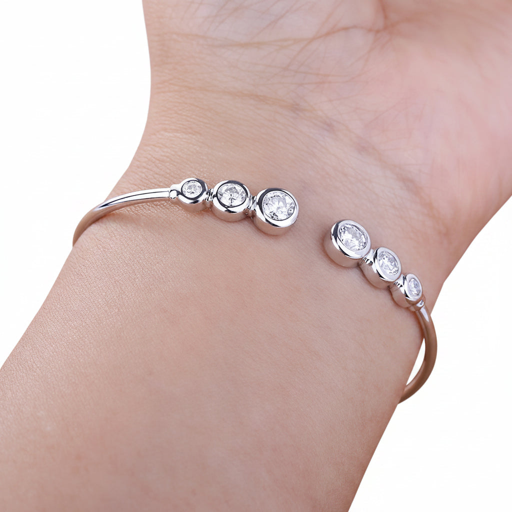 Silver bracelet with round stones on a wrist against a white background