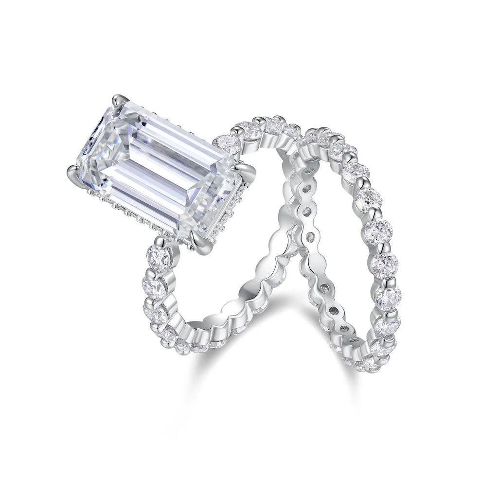 Moissanite diamond ring with emerald-cut center stone and matching band on a white background