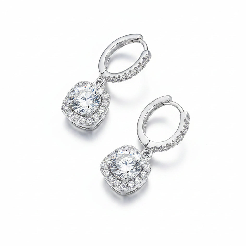 Pair of silver hoop earrings with moissanite gemstones on a white background