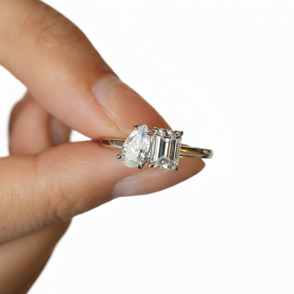 Moissanite ring held between fingers against a white background