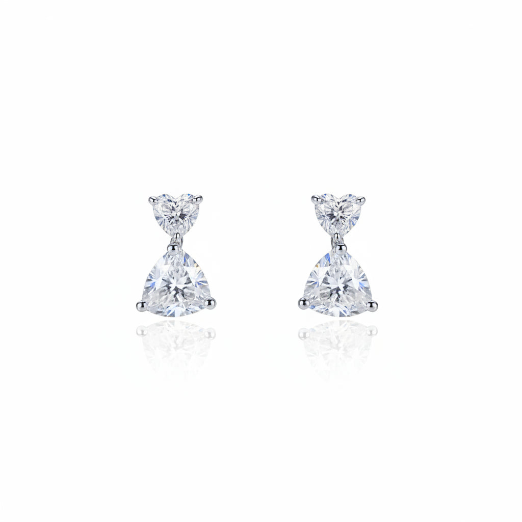 Pair of moissanite diamond earrings on a white cushion with a white background