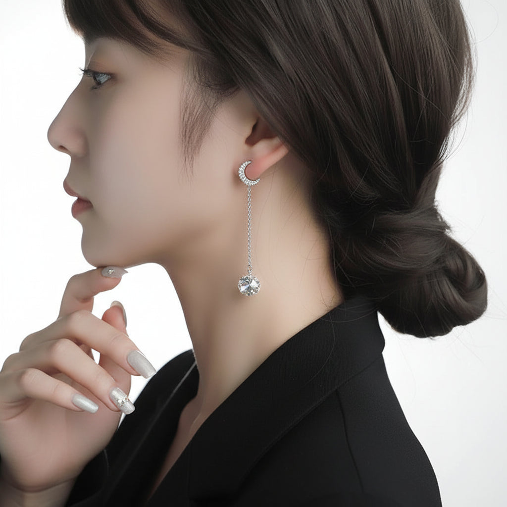 Close-up of a woman wearing a silver earring with a moissanite gemstone against a white background