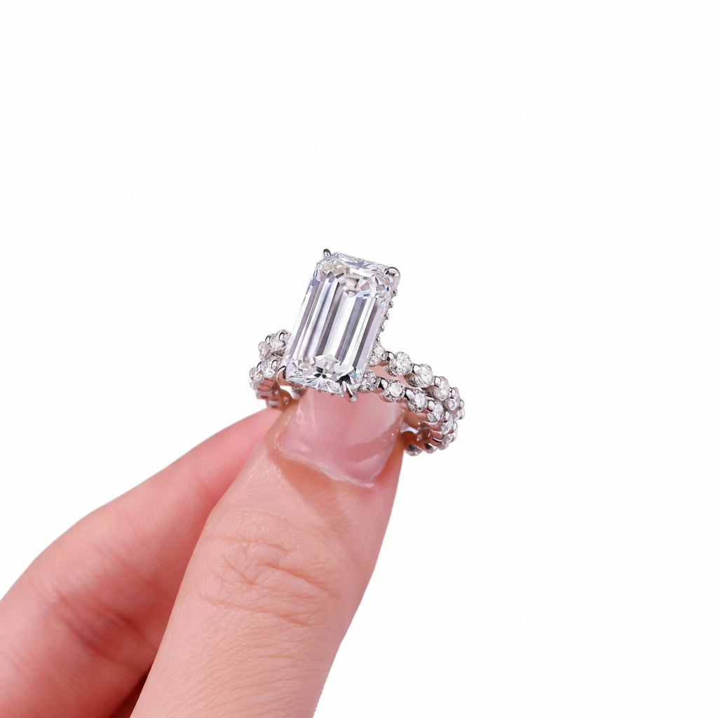Diamond ring held on a finger against a white background