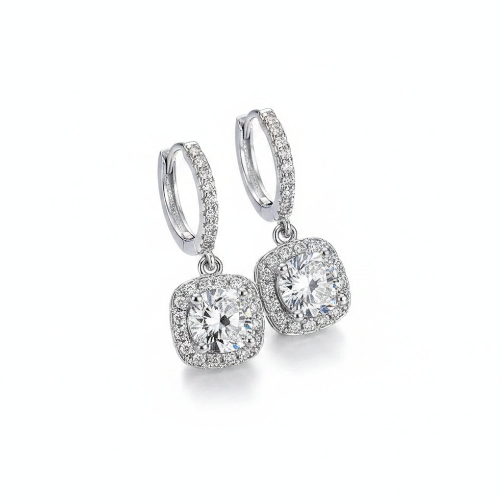 Silver hoop earrings with moissanite gemstones on a white background