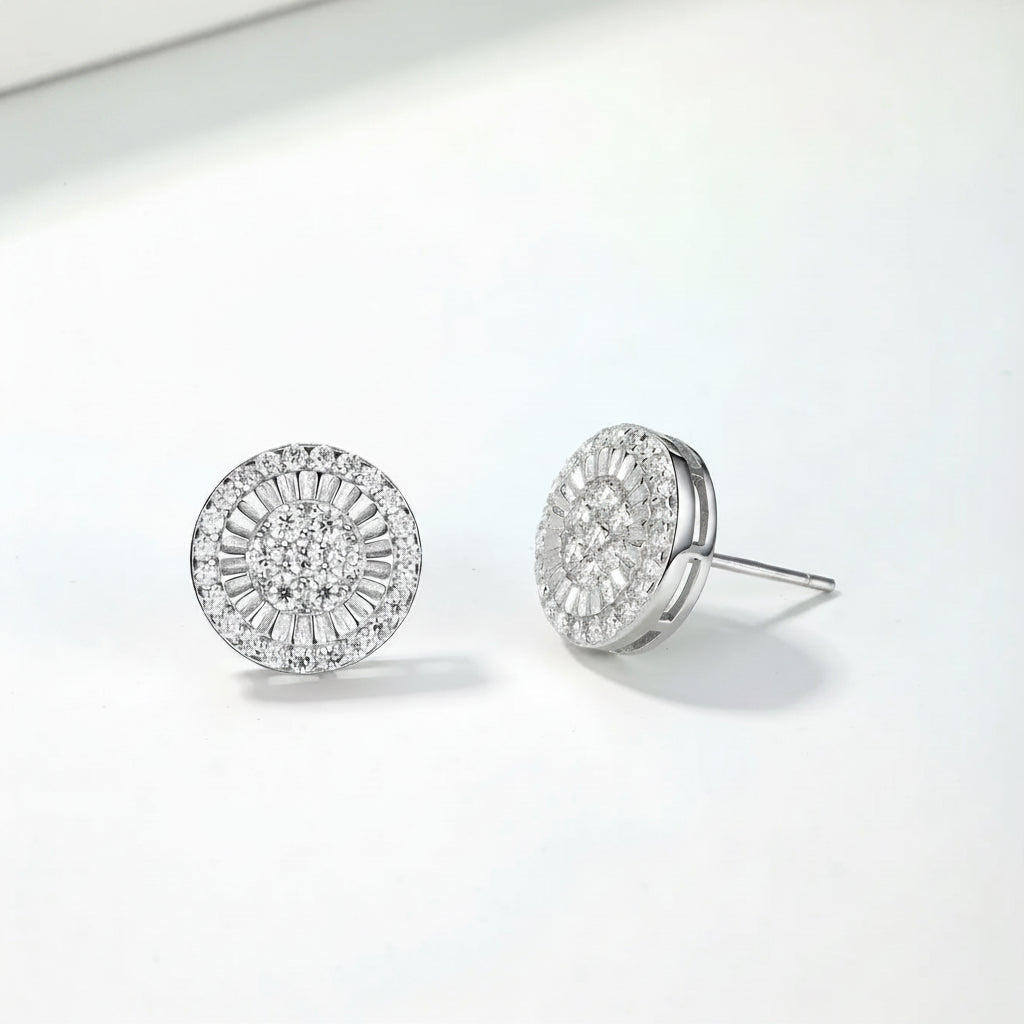 Pair of silver earrings with moissanite stones on a light gray background