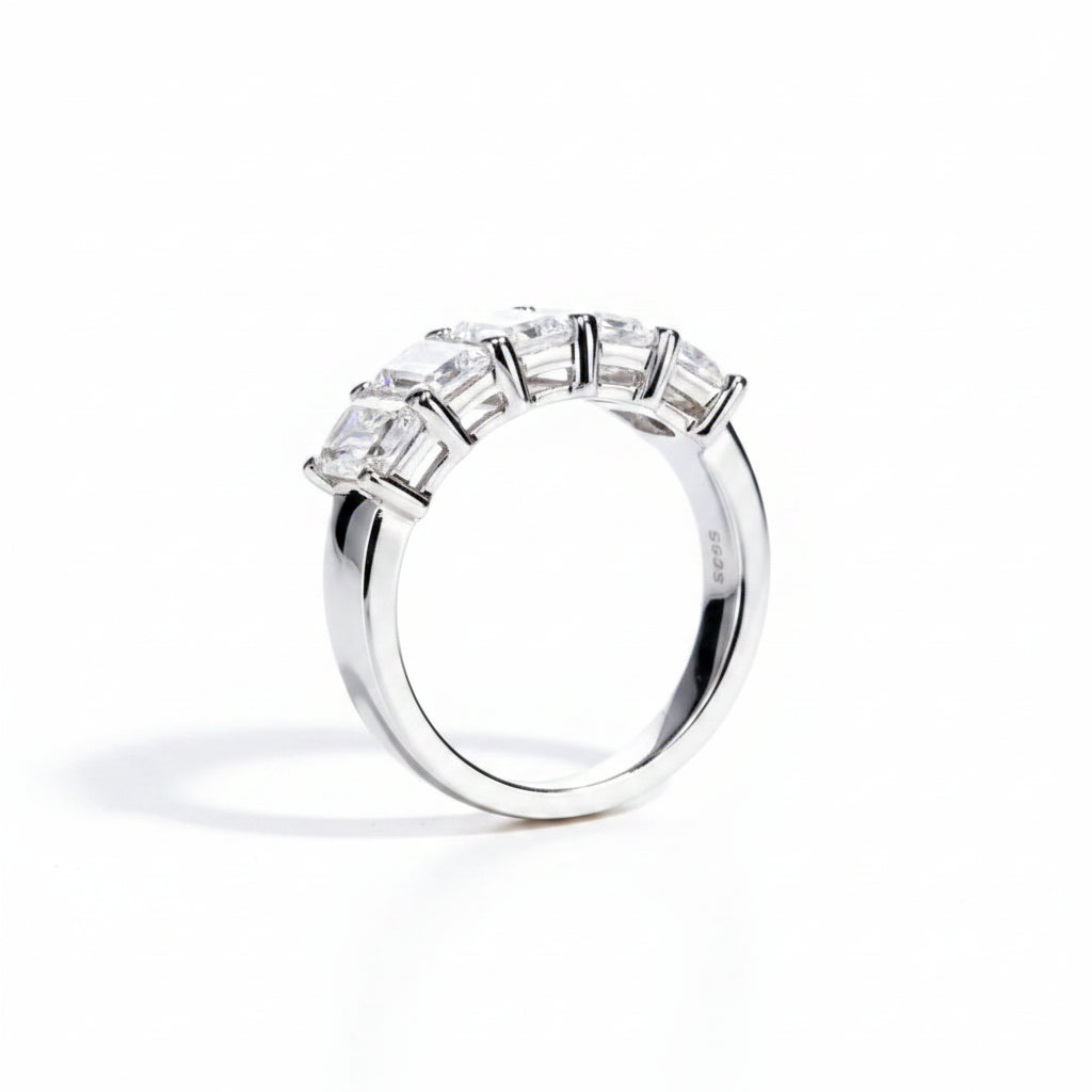 Silver ring with gemstones on a white surface