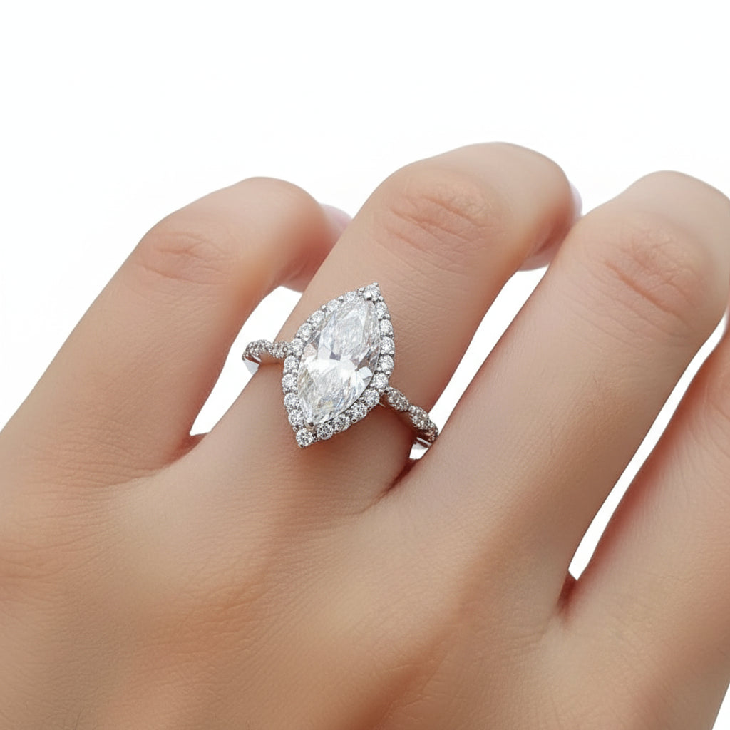 Silver ring with a large moissanite gemstone on a hand.