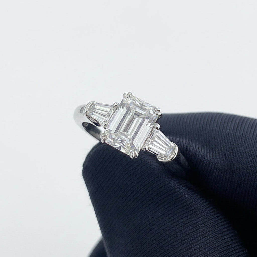Moissanite ring held by a gloved hand against a white background