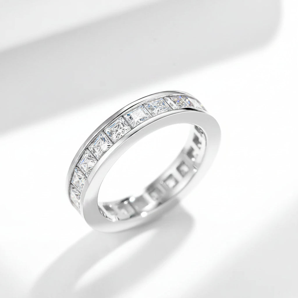 Silver ring with embedded moissanites on a white background