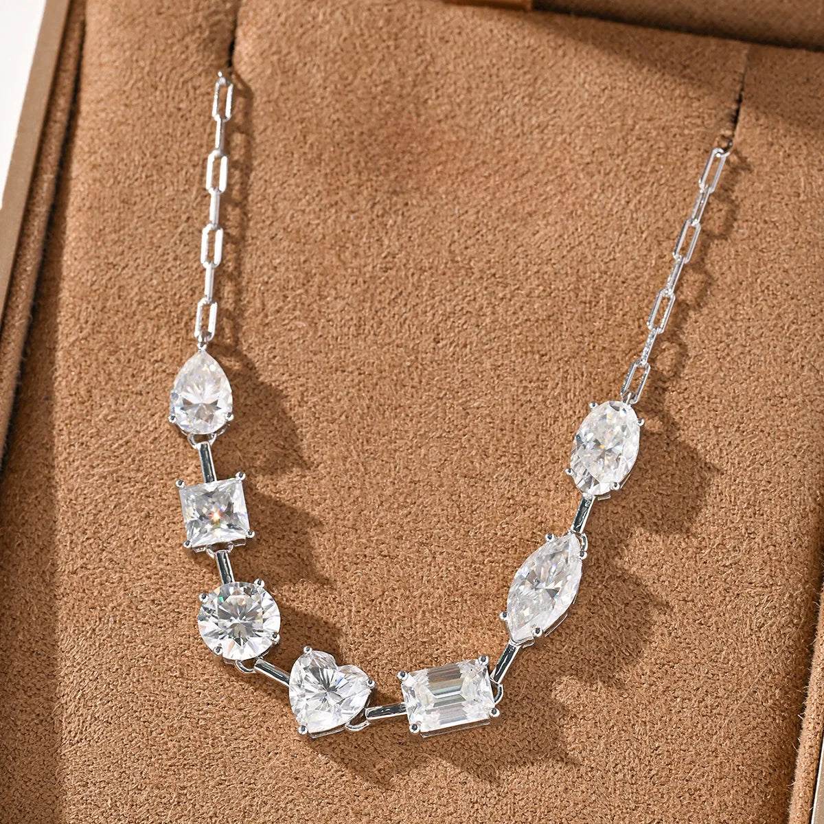 Moissanite diamond necklace on a brown textured surface