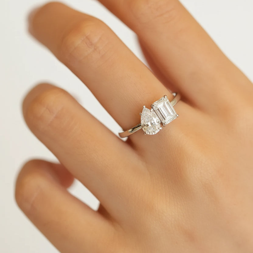 Close-up of a hand wearing a moissanite ring with a blurred background