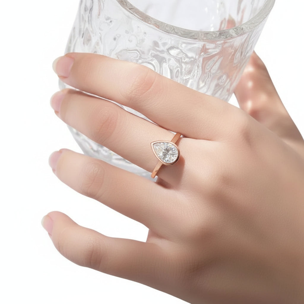 Hand wearing a diamond ring with a white background