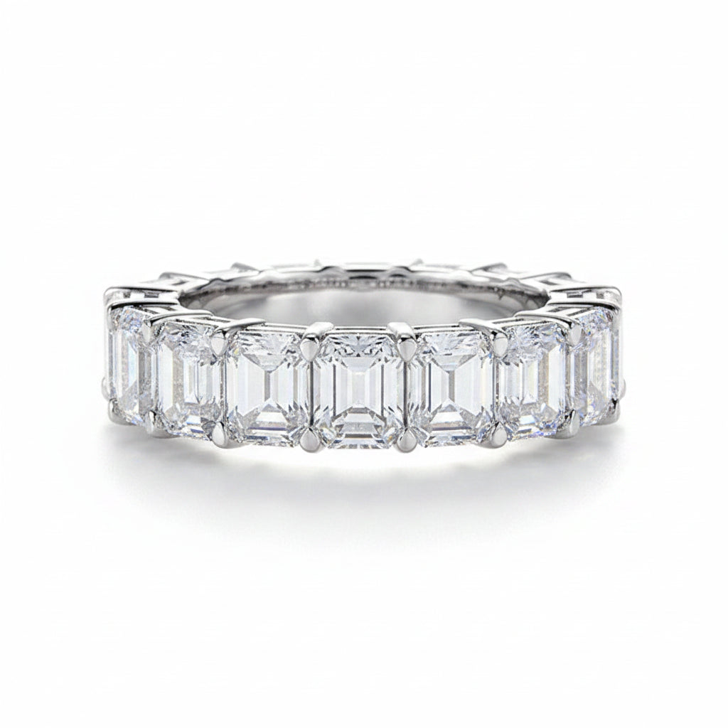 Moissanite ring with emerald-cut stones on a white background.