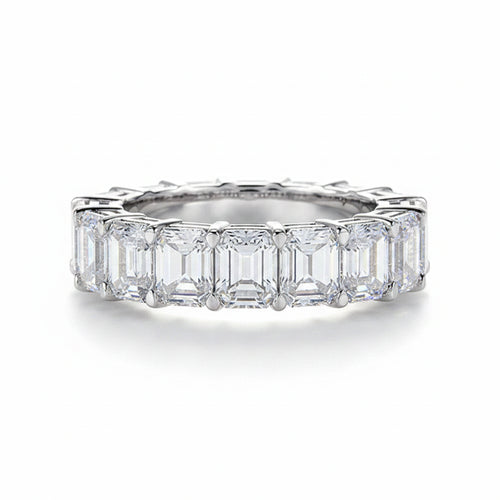 Moissanite ring with emerald-cut stones on a white background.