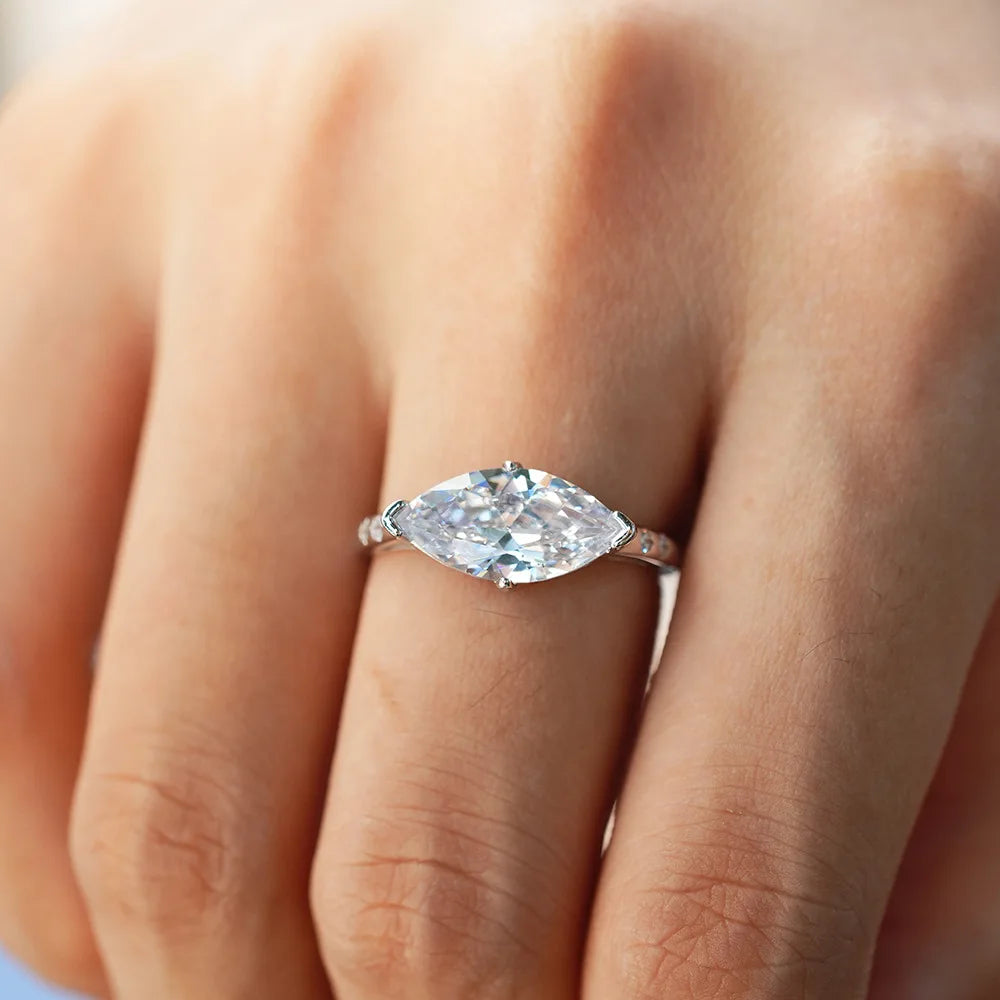 Moissanite ring on a person's finger with a blurred background
