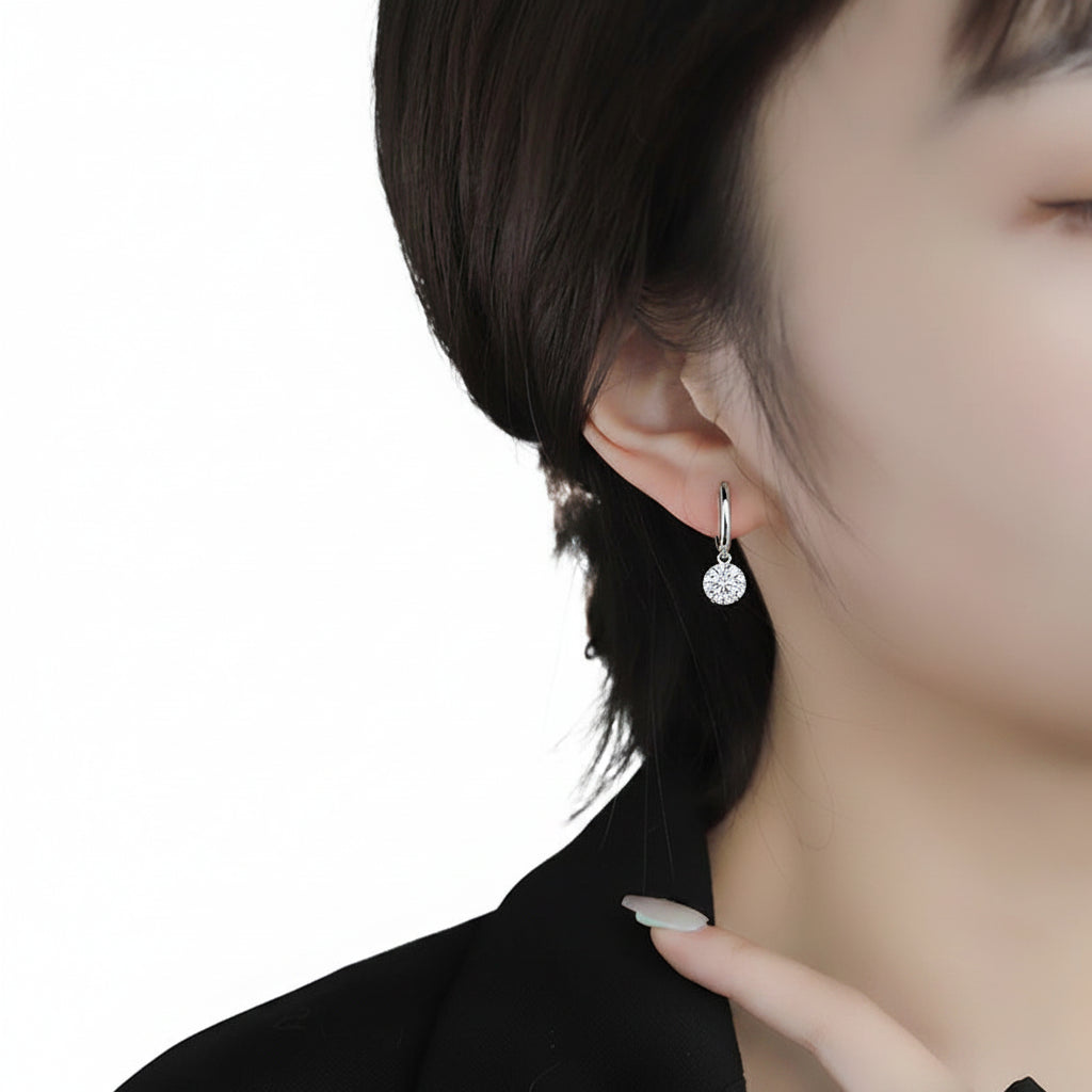 Close-up of a person wearing a silver earring with a white background