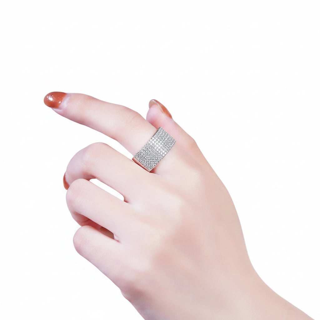 Silver ring on a person's finger with a blurred white background