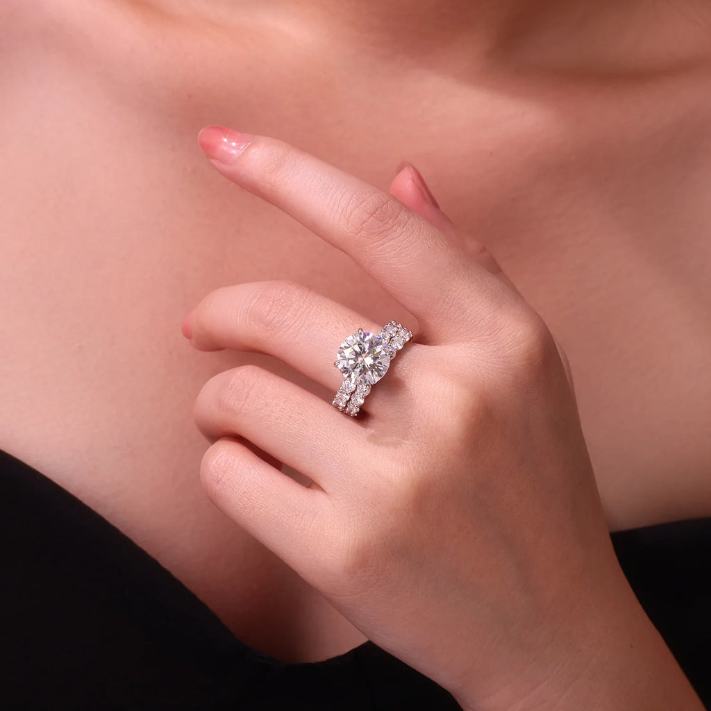 Hand wearing a moissanite ring on a neutral background