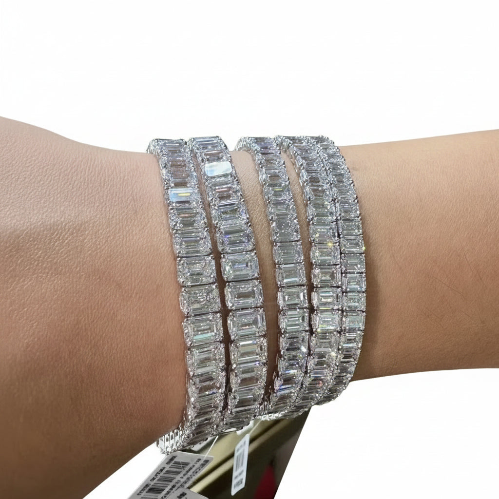 Close-up of a wrist wearing multiple moissanite diamond bracelets with a white background.