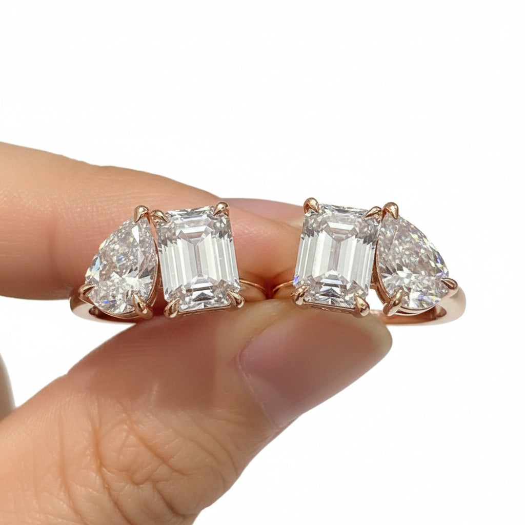 Diamond earrings displayed on a finger against a white background