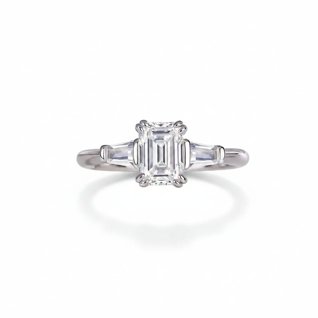 Moissanite ring with emerald-cut center stone on white surface