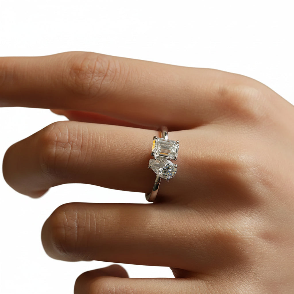 Close-up of a hand wearing a moissanite ring with a white background