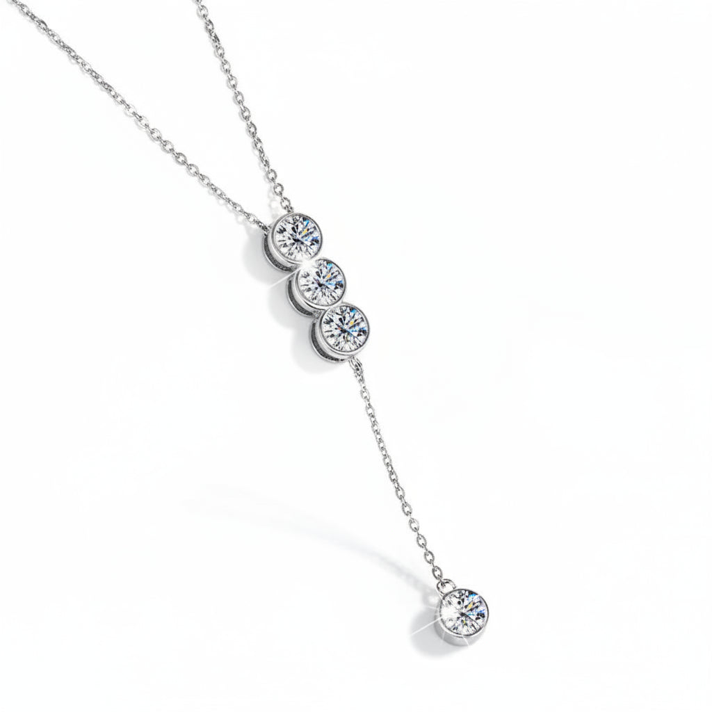 Silver necklace with three circular pendants on a white background