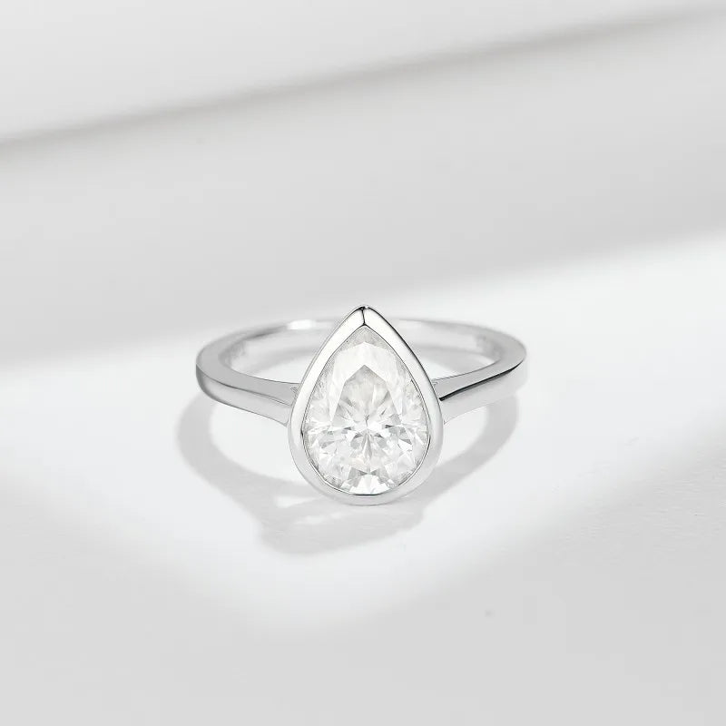 Silver ring with a pear-shaped diamond on a light gray background