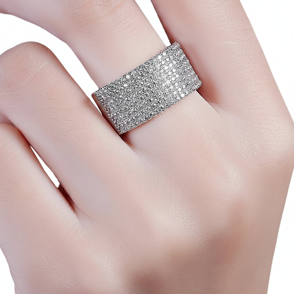 Silver ring with moissanite gemstones on a hand against a white background