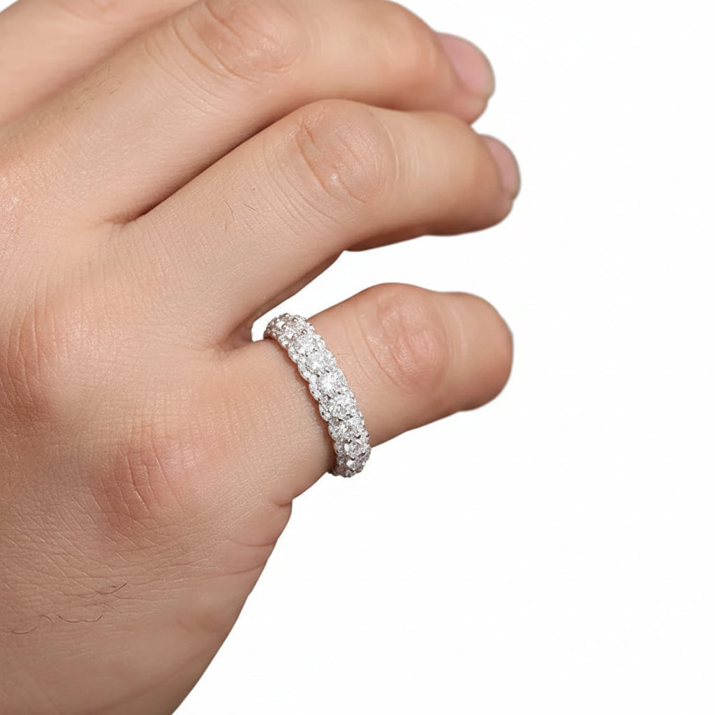 Close-up of a hand wearing a moissanite ring with a white background