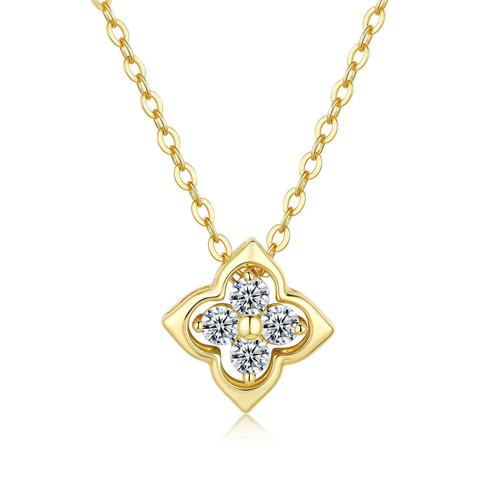 Gold necklace with a clover-shaped pendant featuring four moissanite diamonds on a white background.