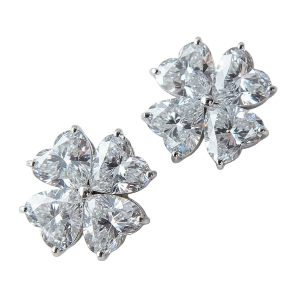 Pair of heart shape moissanite diamond earrings on a white background