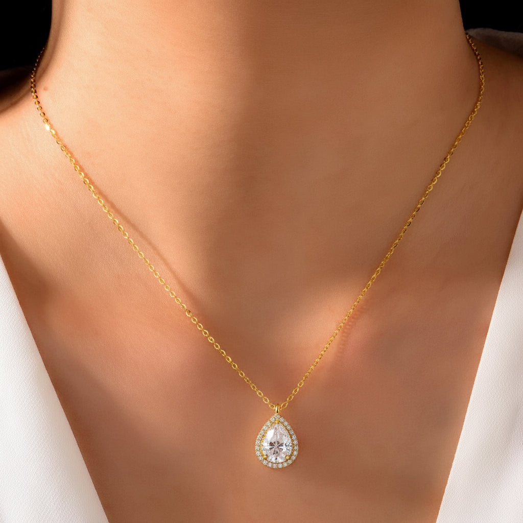 Gold necklace with a moissanite pendant on a person's neck against a white background