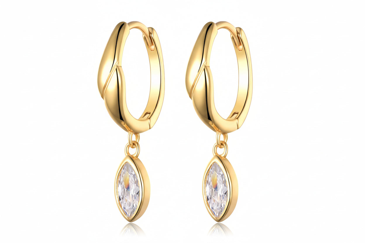 Gold hoop earrings with moissanite gemstones on a white background.