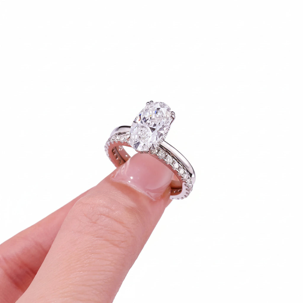 Oval shape moissanite diamond ring on a finger against a white background