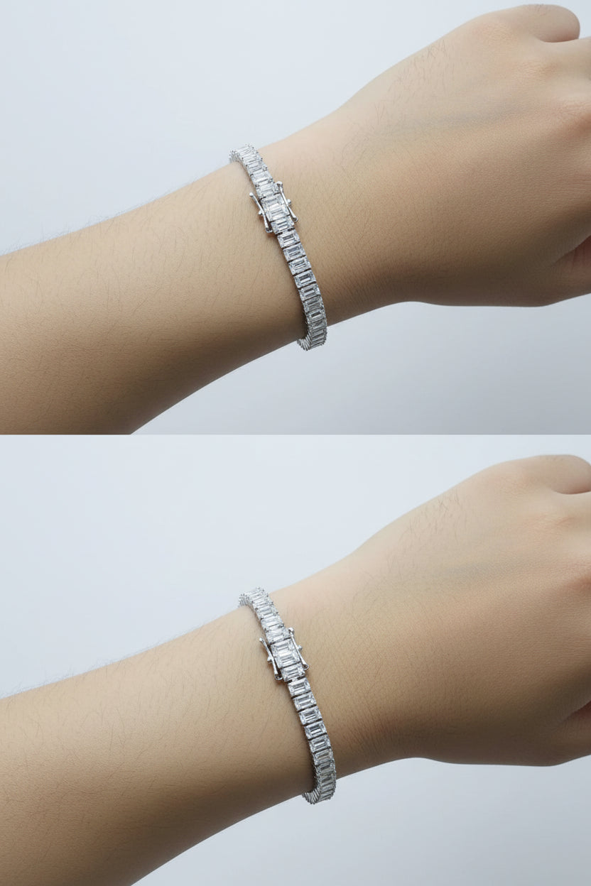 Silver bracelet on a wrist with a neutral background